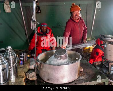 (200512) -- BASISLAGER QOMOLANGMA, 12. Mai 2020 (Xinhua) -- EIN Mitarbeiter kocht Eis im Vorlager auf 6,500 Metern Höhe auf dem Berg Qomolangma, 11. Mai 2020. Das Vorlager liegt auf einem Hang am Ende des East Rongbuk Gletschers und ist das letzte Lager vor der Schneelinie und der Eis- und Schneestraße auf dem Mount Qomolangma. Auch als "Lager der Bösen" bekannt, leiden viele der professionellen Bergführer, die den Gipfel des Mount Qomolangma unzählige Male erreicht haben, aufgrund ihrer geographischen Lage an Höhenkrankheit. Es ist eine Gegend, umgeben von Bergen und schlechter Luft CI Stockfoto