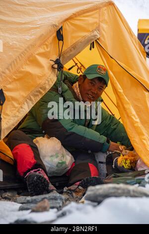 (200512) -- MOUNT QOMOLANGMA BASISLAGER, 12. Mai 2020 (Xinhua) -- EIN Bergführer sitzt in einem Zelt im Vorlager auf 6,500 Metern Höhe auf dem Berg Qomolangma, 10. Mai 2020. Das Vorlager liegt auf einem Hang am Ende des East Rongbuk Gletschers und ist das letzte Lager vor der Schneelinie und der Eis- und Schneestraße auf dem Mount Qomolangma. Auch als "Lager der Bösen" bekannt, leiden viele der professionellen Bergführer, die den Gipfel des Mount Qomolangma unzählige Male erreicht haben, aufgrund ihrer geographischen Lage an Höhenkrankheit. Es ist eine Gegend, umgeben von Bergen und Armen Stockfoto