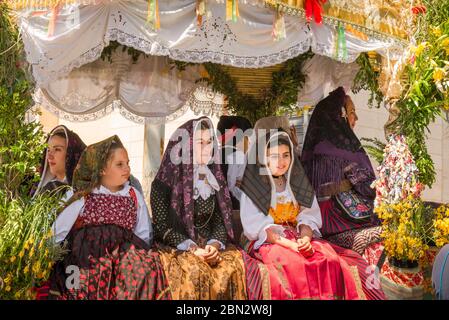 Sardinien Volksfest Kinder, drei Mädchen in traditioneller Kleidung reiten während der Cavalcata Festprozession in Sassari, Sardinien, einen geschmückten Festwagen Stockfoto