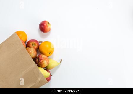Äpfel und Birnen in einem Papiertütchen Bastelpapier auf weißem Hintergrund. Freier Platz für Ihren Text. Draufsicht. Stockfoto