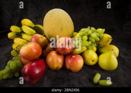 Gemüse und Obst Kohl Banane Melone Traube Orange Äpfel Birne einen dunklen Hintergrund Stockfoto