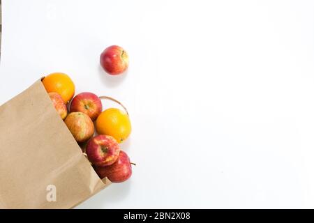 Äpfel und Birnen in einem Papiertütchen Bastelpapier auf weißem Hintergrund. Freier Platz für Ihren Text. Draufsicht. Stockfoto
