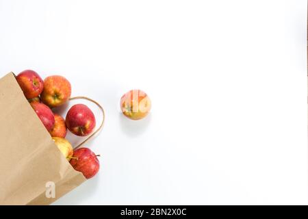 Äpfel und Birnen in einem Papiertütchen Bastelpapier auf weißem Hintergrund. Freier Platz für Ihren Text. Draufsicht Stockfoto