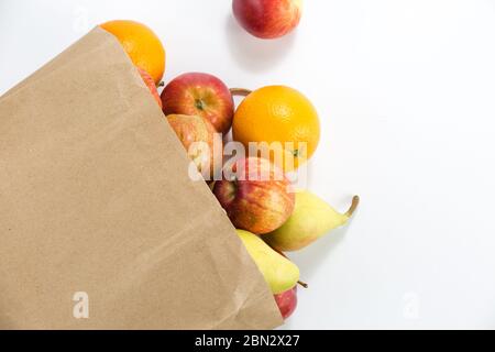 Äpfel und Birnen in einem Papiertütchen Bastelpapier auf weißem Hintergrund Stockfoto