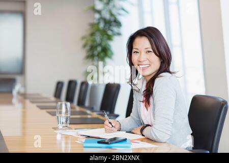 Porträt zuversichtlich lächelnde Geschäftsfrau arbeitet im Konferenzraum Stockfoto