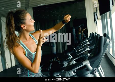 Frau ist mit Smart Watch während ihres Trainings im Fitnessstudio Stockfoto