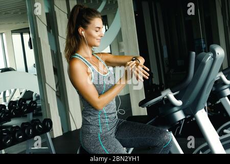 Frau ist mit Smart Watch während ihres Trainings im Fitnessstudio Stockfoto