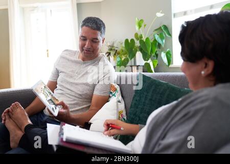 Ältere Paare mit digitalen Tablet auf dem Sofa im Wohnzimmer Stockfoto