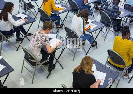 Schüler, die an den Schreibtischen im Klassenzimmer Prüfung ablegen Stockfoto