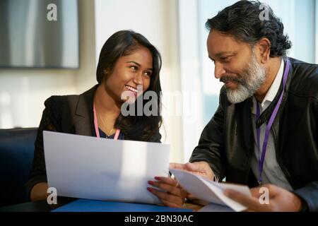 Lächelnde Geschäftsleute diskutieren Schreibarbeit im meeting Stockfoto