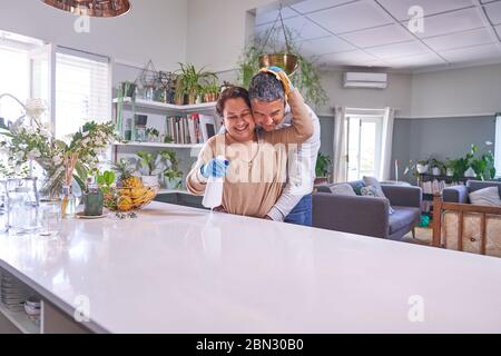 Zärtlich reifen Paar umarmen und Reinigung Küche Insel Stockfoto