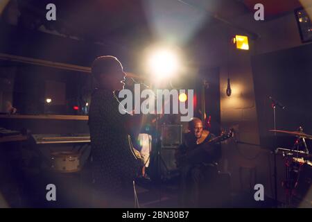 Musikerin singt ins Mikrofon im Aufnahmestudio Stockfoto