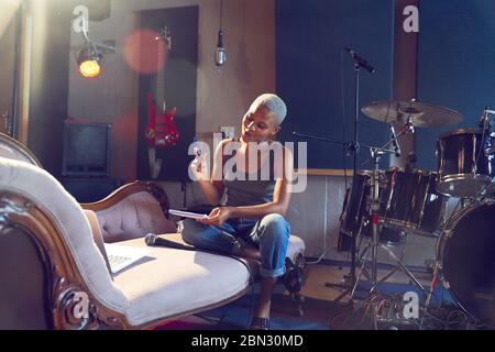 Junge Musikerin Song schriftlich im Aufnahmestudio Stockfoto