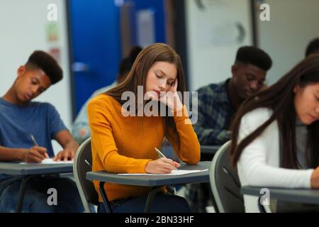 Fokussierte High School Mädchen Schüler, die Prüfung am Schreibtisch im Klassenzimmer Stockfoto