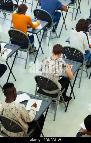 Schüler, die an den Schreibtischen im Klassenzimmer Prüfung ablegen Stockfoto