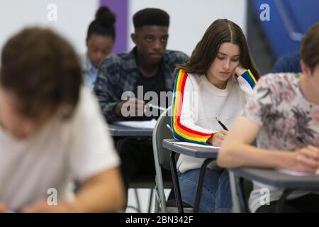 Schüler, die an den Schreibtischen im Klassenzimmer Prüfung ablegen Stockfoto