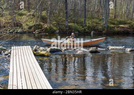 Fischer Trolling von Ruderboot / Schiff am Fluss Nokienkoski, Finnland Stockfoto