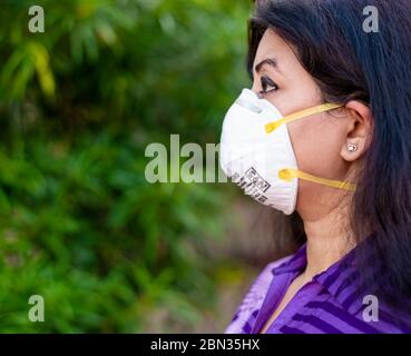 Eine indische Dame, die N95 Maske benutzt, um sich selbst zur Zeit der Pandemie zu schützen Covid19/ Corona Virus. Stockfoto