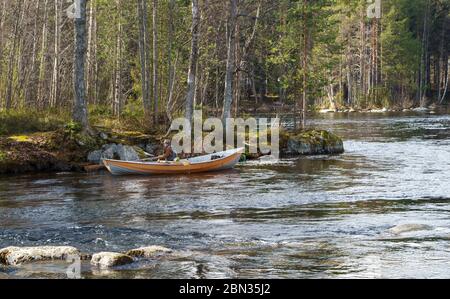 Fischer Trolling von Ruderboot / Schiff am Fluss Nokienkoski, Finnland Stockfoto