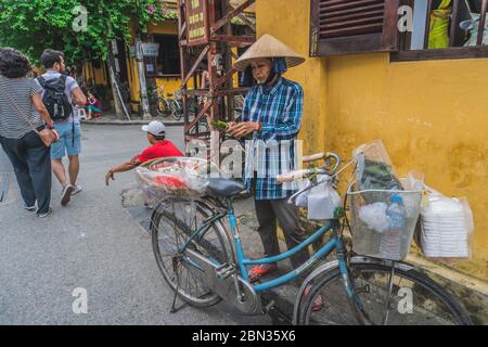 Wundervolle Aussicht auf die alte Straße, die mit bunten Seidenlaternen dekoriert ist. Vietnamesen in traditionellen schließt Spaziergang entlang Hoi an Altstadt. Hoi an (Hoi an), Vietnam - 12. März 2020. Stockfoto