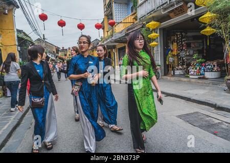 Wundervolle Aussicht auf die alte Straße, die mit bunten Seidenlaternen dekoriert ist. Vietnamesen in traditionellen schließt Spaziergang entlang Hoi an Altstadt. Hoi an (Hoi an), Vietnam - 12. März 2020. Stockfoto