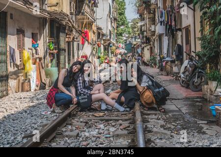 Mädchen machen Fotos auf Eisenbahnschienen. Hanoi, Vietnam - 2. März 2020. Stockfoto