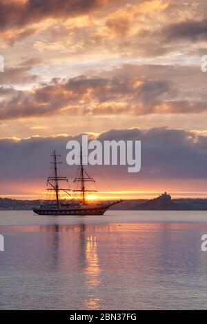 Ein großes Schiff legte bei Sonnenaufgang in Mounts Bay an, in der Ferne war St. Michael's Mount Stockfoto