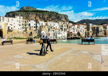 Menschen, die auf dem Damm in der Altstadt von Cefalu, Sizilien, Italien. Stockfoto