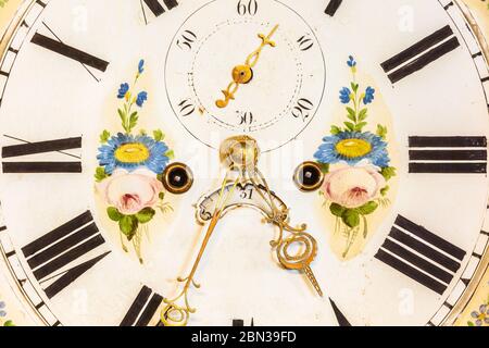 Nahaufnahme einer antiken ornamentalen Uhr mit handbemalten Blumenschmuck Stockfoto