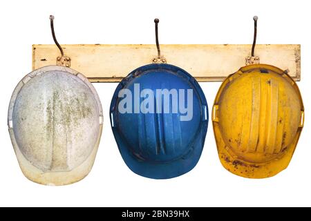 Drei Bauhelme hängen auf einem Hutablage isoliert auf weißem Hintergrund Stockfoto