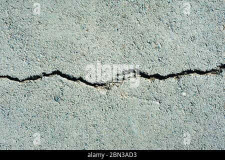 Straßenbelag, Straßenpflaster, Risse im Asphalt. Auflösung alten Betonzement mit Rissen und natürliche Zerstörung von Zeit und Wetterbedingungen Stockfoto