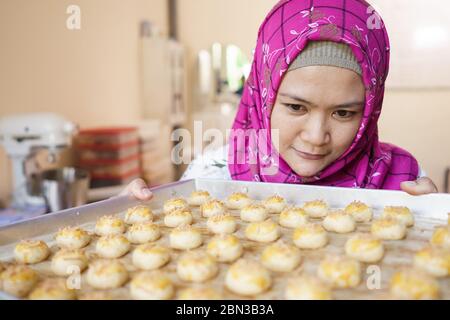 muslimische Frau Kuchen Shop Besitzer. Hausgemachte Backen machen einige Nastar oder Ananas Torte Kuchen zu Hause Stockfoto