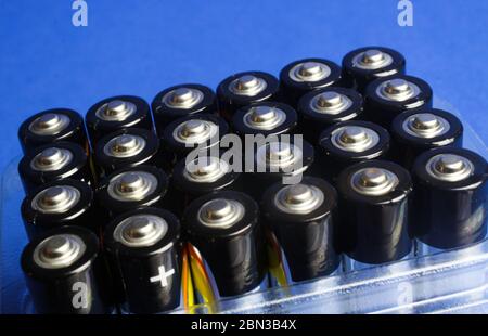 Viersen, Deutschland - 9. Mai. 2020: Makro Nahaufnahme vieler Alkali-Batterien in Kunststoffbox, blauer Hintergrund Stockfoto