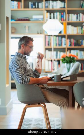 Geschäftsmann mit digitalen Tablet, von zu Hause aus arbeiten Stockfoto