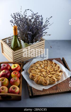 Apfelkuchen und Äpfel. Runde hausgemachte Kuchen. Einfacher Teig aus Mürbeteig und karamellisiertem Apfel. Süßes Gebäck. Stillleben mit Lavendel Stockfoto