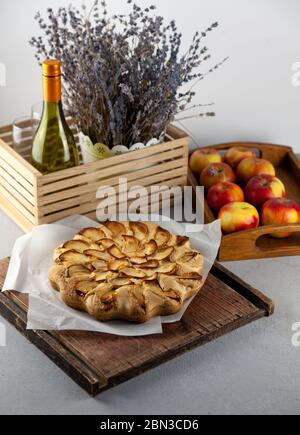 Apfelkuchen und Äpfel. Runde hausgemachte Kuchen. Einfacher Teig aus Mürbeteig und karamellisiertem Apfel. Süßes Gebäck. Stillleben mit Lavendel Stockfoto