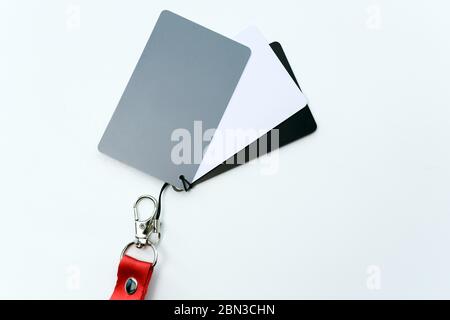 Graue Karte mit rotem Band, ein Werkzeug für Fotografen, das den richtigen Weißabgleich bestimmt, ein Ort, um Platz zu kopieren Stockfoto