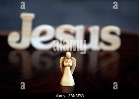 Holzbuchstaben bilden das Wort Jesus mit Engel. Christliches Symbol. Stockfoto