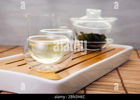 Aus der Teekanne wird heißer grüner Tee gegossen. Nahaufnahme, Teezeremonie Stockfoto