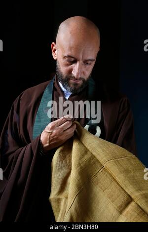 Zen Mönch näht traditionelle Kleidung in Villejuif, Frankreich. Stockfoto