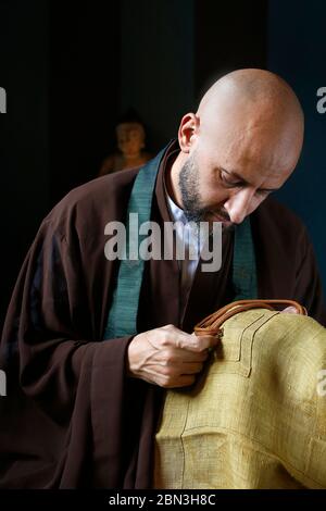 Zen Mönch näht traditionelle Kleidung in Villejuif, Frankreich. Stockfoto