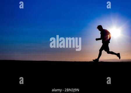 TAMESIDE, GROSSBRITANNIEN. 25 Mai 2016. Ein Jogger, der bei Sonnenuntergang in Stalybridge, Greater Manchester, auf dem Gipfel des Ridge Hill läuft. © Foto Matthew Lofthouse - Freiberuflicher Fotograf Stockfoto