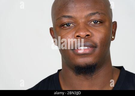 Gesicht des glücklichen jungen schönen kahlen afrikanischen Mann lächelnd Stockfoto