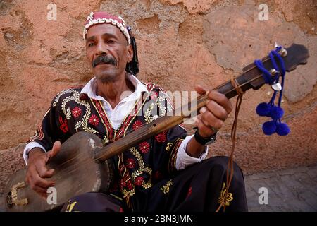 Gnawa Musiker sitzt in einer Straße in Marrakesch Medina (Altstadt), Marokko. Stockfoto