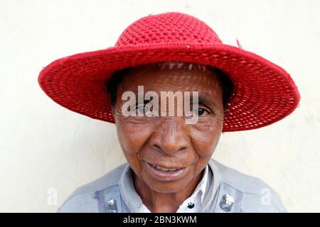 Die madagassische Frau mit einem roten Hut schmunzend. Hochformat. Madagaskar. Stockfoto