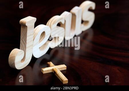 Holzbuchstaben bilden das Wort JESUS und Kreuz. Christliches Symbol. Stockfoto