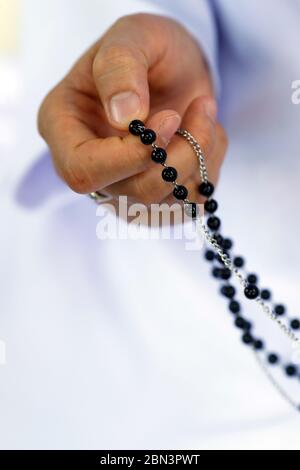 Dominikanische Nonne zahlt die Rosenkranz Perlen. Nahaufnahme der Hände. Vietnam. Stockfoto