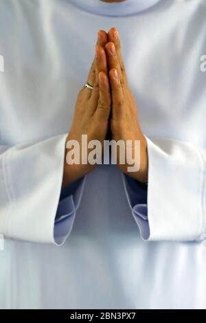 Dominikanische Nonne bezahlt. Nahaufnahme der Hände. Vietnam. Stockfoto