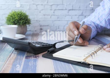 Nahaufnahme der Person Hand Schreiben auf Notizblock. Stockfoto