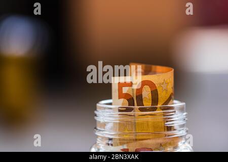 Komposition mit Spargeld-Banknoten (50 EURO) in einem Glasgefäß. Konzept der Investition und halten Geld, Nahaufnahme isoliert. Stockfoto